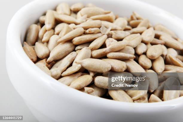 close-up of peeled sunflower seed isolated on white background - bird seed stockfoto's en -beelden