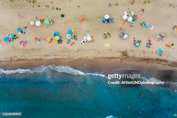 viele unerkennbare menschen am strand, tropische stimmungund urlaub - beach vibes stock-fotos und bilder