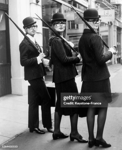 Trois mannequins britanniques présentent dans les rues de la City trois modèles en tissu à rayures avec de gauche à droite, pantalon et veste comme...