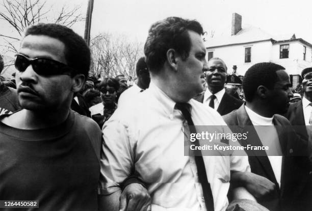 Bras dessus, bras dessous, un groupe d'hommes blancs et noirs dans le cortège funéraire, à Atlanta, Géorgie, Etats-Unis le 9 avril 1968.