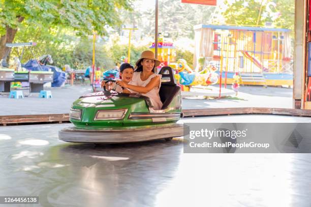 mutter und sohn im stoßstangenwagen auf der kirmes - autoscooter stock-fotos und bilder