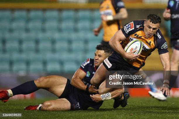 Tom Banks of the Brumbies is tackled by Matt Toomua of the Rebels during the round 6 Super Rugby AU match between the Rebels and Brumbies at...