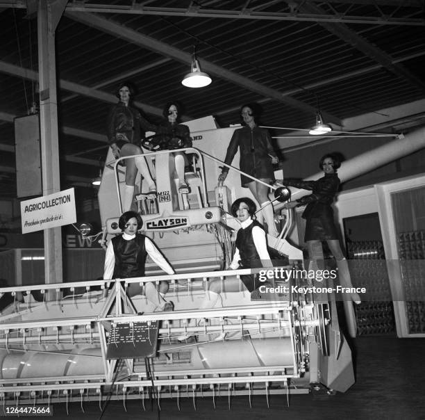 Mannequins présentant des modèles en cuir sur une moissonneuse-batteuse lors du salon de la machine agricole, à Paris, France le 5 mars 1968.