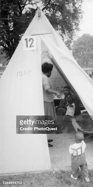 Unidentified members of a family settle into one of the tent homes in 'Resurrection City,' temporary housing for marchers and activists taking part...