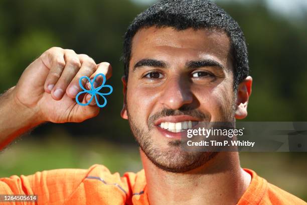 Athlete Adam Gemili poses with the Alzeimer's Society pin badge as he takes part in an Alzheimer's Society memory walk, to honour his Grandmother who...