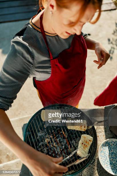 woman preparing halloumi cheese on barbecue grill - grilled halloumi stock pictures, royalty-free photos & images