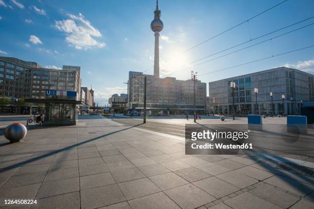 germany, berlin, sun shining over empty alexanderplatz during covid-19 pandemic - deutschland stock-fotos und bilder