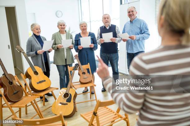 seniors in retirement home making music singing in choir - music therapy stock pictures, royalty-free photos & images