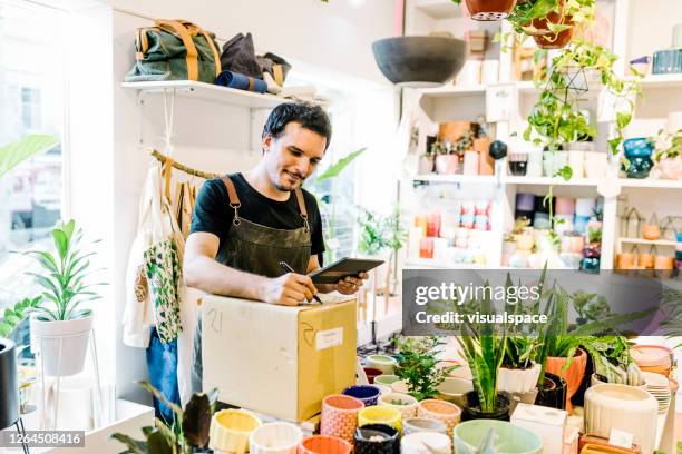 propietario de pequeñas empresas llenando pedidos en línea - tienda de regalos fotografías e imágenes de stock