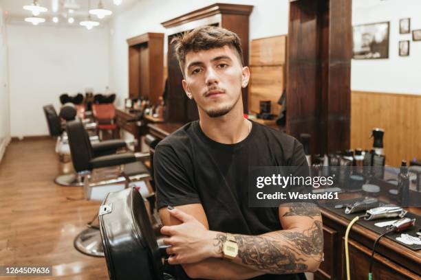 trendy hairdresser standing arms crossed at salon - coiffeur photos et images de collection