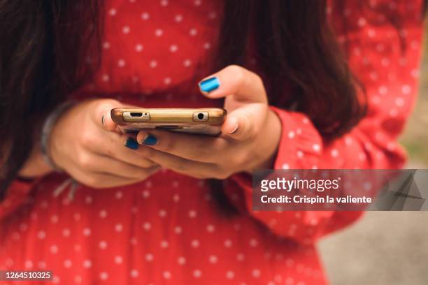 a girl uses a mobile phone . - one teenage girl only ストックフォトと画像