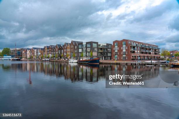 netherlands, north holland, haarlem, houses alongspaarne river canal - haarlem stock pictures, royalty-free photos & images