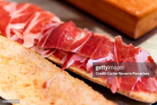 bread spread with tomato and slices of iberian ham on top on a metal surface - comunidad autónoma de extremadura fotografías e imágenes de stock