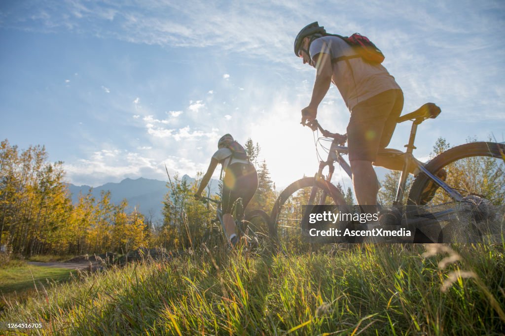 Mountainbiker fährt im Herbst auf Grasweg