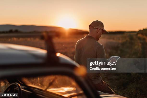 mid adult farmer inspects his land - rural internet stock pictures, royalty-free photos & images