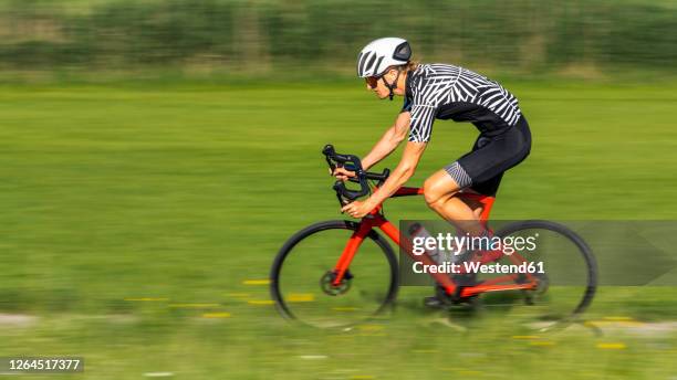 man riding his racing bike - velofahren stock-fotos und bilder