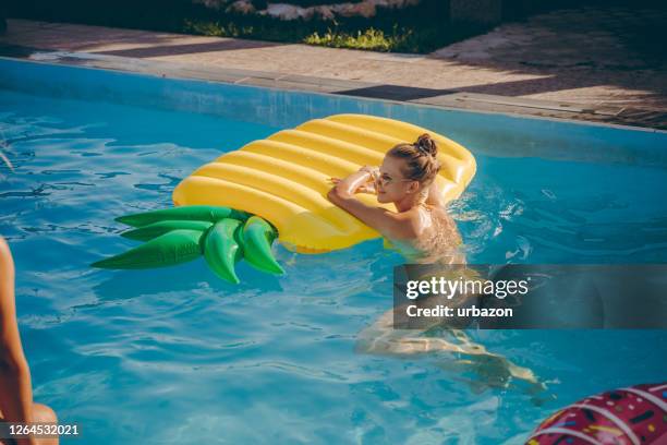 woman enjoying in swimming pool - lilo stock pictures, royalty-free photos & images