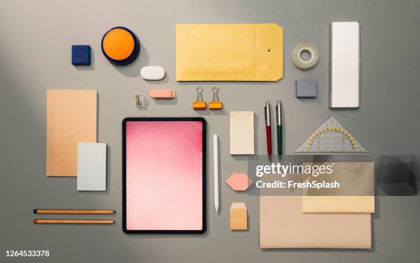 flat lay still life comprising a collection of office-related objects regularly used on a businessperson's desk, a tablet placed among them - tidy desk stock pictures, royalty-free photos & images