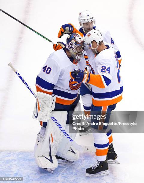 Semyon Varlamov of the New York Islanders is congratulated by teammates Scott Mayfield and Andy Greene after the 5-1 win over the Florida Panthers...