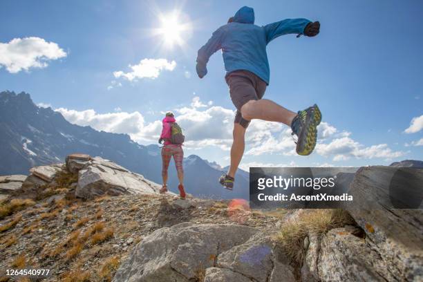 trail runners ascend high mountain ridge - leap forward stock pictures, royalty-free photos & images