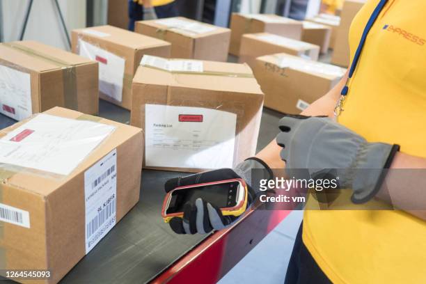 close-up of post office employee using a bar code reader on a package - mailroom stock pictures, royalty-free photos & images