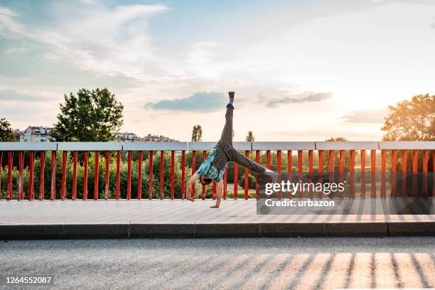 man doing cartwheel on bridge - cartwheel stock pictures, royalty-free photos & images