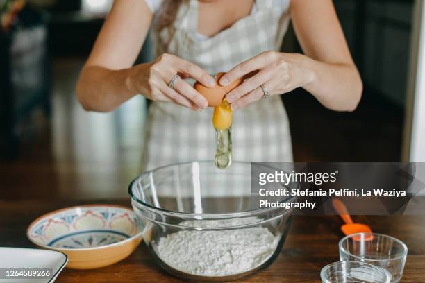 hands breaking an egg in a bowl - woman back stock-fotos und bilder