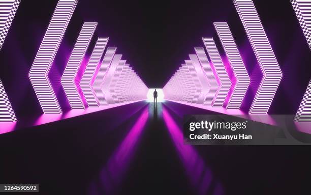 man standing in empty futuristic passage - neon tunnel stock pictures, royalty-free photos & images
