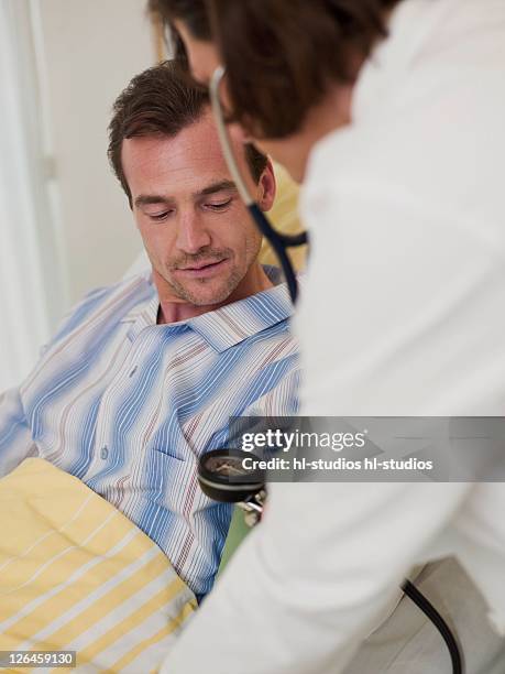 female doctor examining male patient - krankenhaus stock pictures, royalty-free photos & images