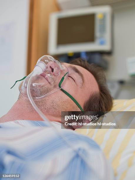 patient wearing oxygen mask in hospital - hospital ventilator stock pictures, royalty-free photos & images