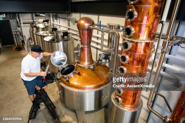 master distiller working at a craft distillery - distillery stock pictures, royalty-free photos & images
