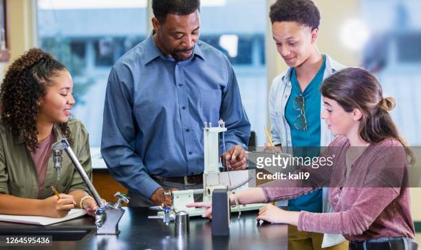 teacher and students in high school physics - physics experiment stock pictures, royalty-free photos & images