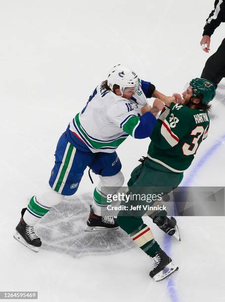 Jake Virtanen of the Vancouver Canucks and Ryan Hartman of the Minnesota Wild fight during the first period in Game Four of the Western Conference...