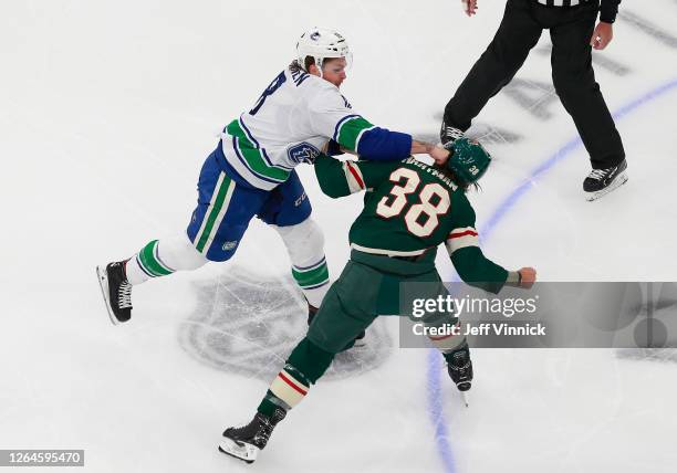 Jake Virtanen of the Vancouver Canucks and Ryan Hartman of the Minnesota Wild fight during the first period in Game Four of the Western Conference...