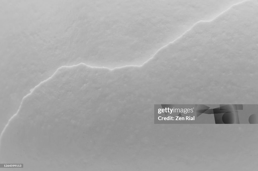 Extreme close-up of overlapping white eggshells creating diagonal crooked line