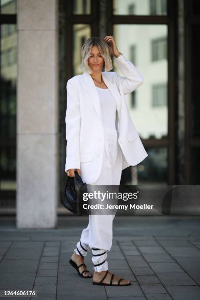 Kathrin Bommann wearing Malaikaraiss suit and chain, Bottega Veneta bag, Ancient Greek sandals and Zara top on August 07, 2020 in Cologne, Germany.