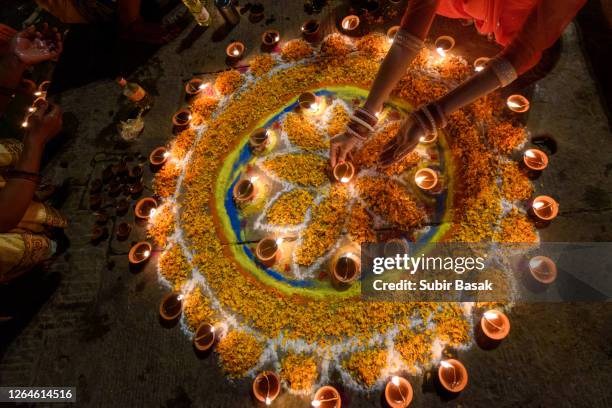 woman hand lighting diyas during diwali,varanasi,uttar pradesh,india. - hindu stock-fotos und bilder