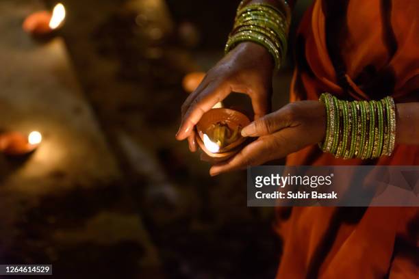 woman hand holding diyas during diwali,varanasi,uttar pradesh,india. - diwali stock-fotos und bilder