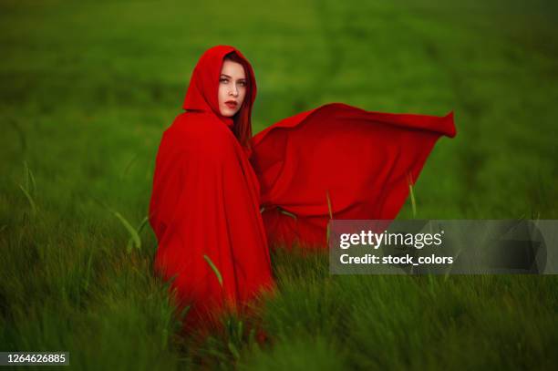 capucha roja en el campo verde - cape garment fotografías e imágenes de stock
