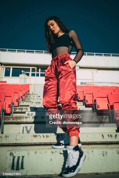 street styled beautiful woman in an empty sports stadium - street style stock pictures, royalty-free photos & images