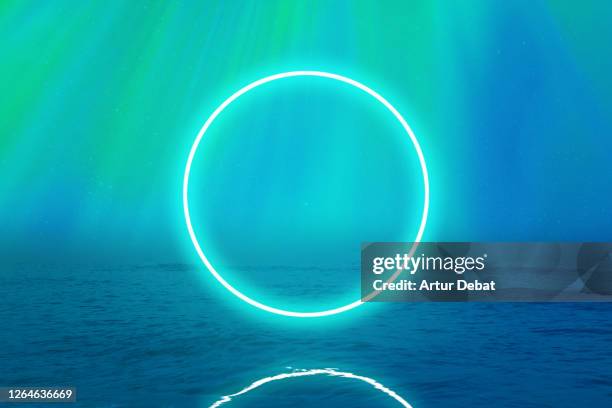 perfect green neon ring glowing over the sea with stunning northern lights in iceland. - divinità foto e immagini stock