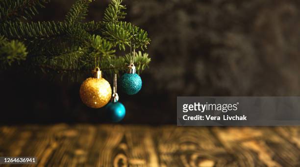 christmas tree decorated with golden blue ornaments on wood floor. defocused lights in the background. copy space for creative use. new year concept. - christmas background copy space stock pictures, royalty-free photos & images