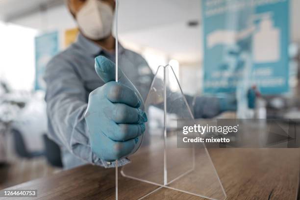 man fixing acrylic glass at office counter - infection prevention imagens e fotografias de stock