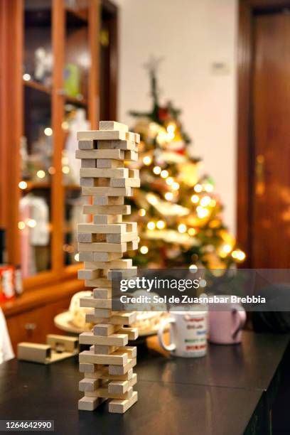 closeup of a set of stacked wooden blocks on the dining table next to the christmas tree - christmas tree close up stock pictures, royalty-free photos & images