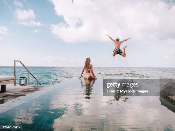 couple enjoying luxury vacations - hotel pool stock pictures, royalty-free photos & images