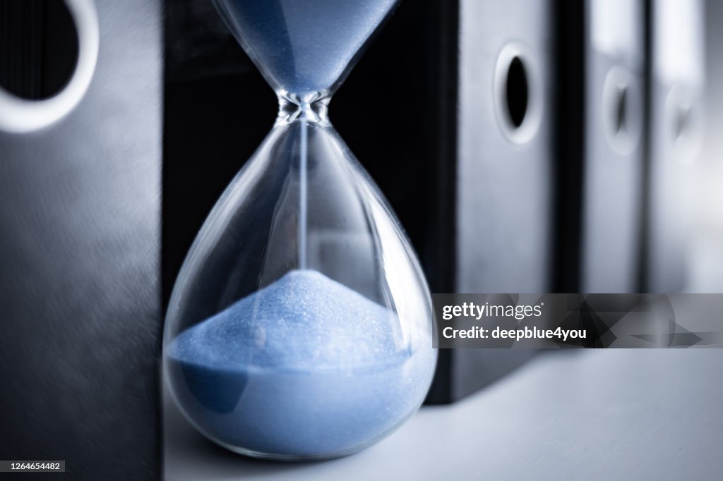 An hourglass runs between file folders