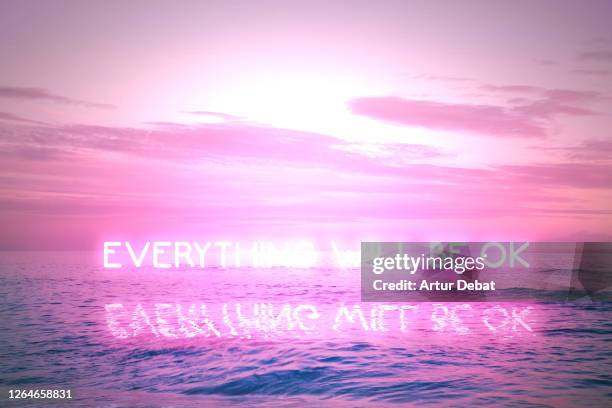 everything will be ok message during covid pandemic with neon lights in sunset seascape. - nueva-normalidad-concepto fotografías e imágenes de stock