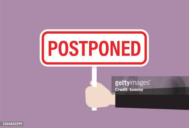 businessman holds a postponed sign - postponed stock illustrations
