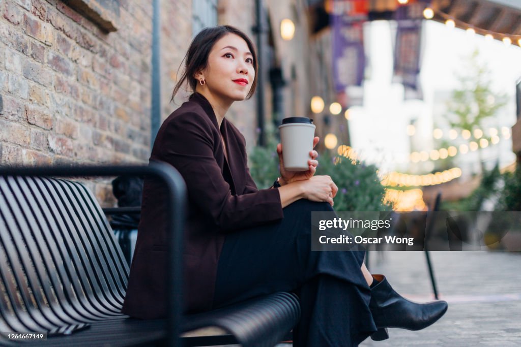 Confident Young Woman Drinking Coffee, Sitting At A Sidewalk Cafe