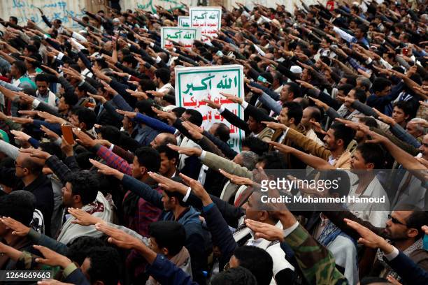 Yemeni loyalists of the Shi'ite Houthi movement hold their hands as they shout slogans during a rally held for celebrating the anniversary of Eid...